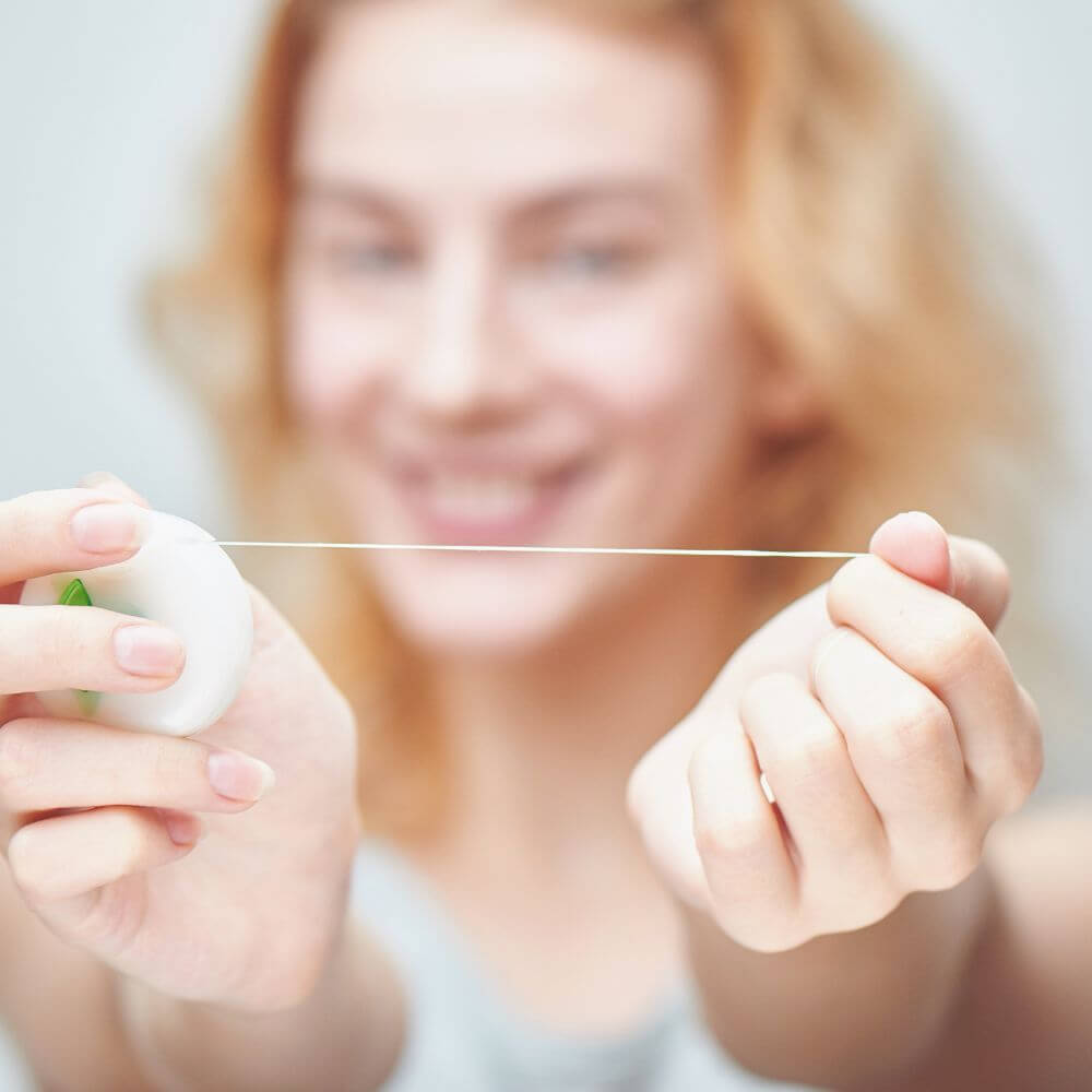 Flossing at home to prevent gum disease